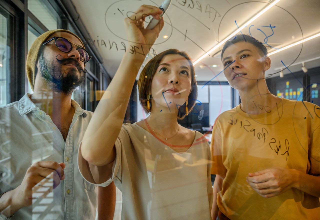 Crafting Captivating Headlines: Your awesome post title goes here Group of diverse professionals collaborating on a glass board in a modern office setting.